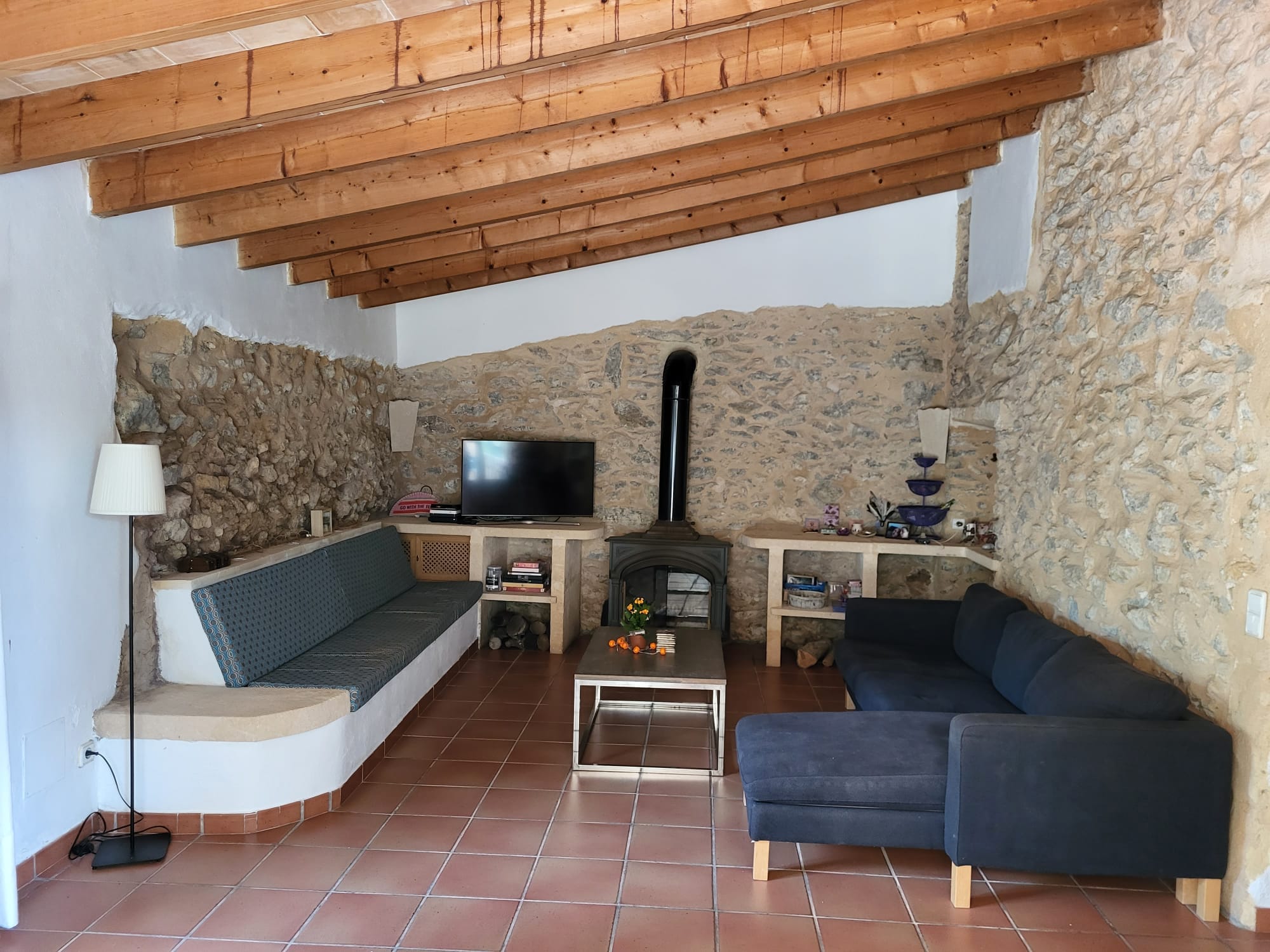 The living room at Casa Romana with stone walls and a wood-burning stove